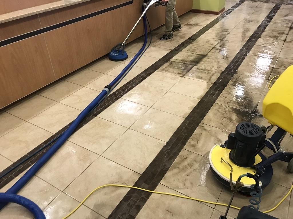 A rotary machine scrubbing a commercial tile floor